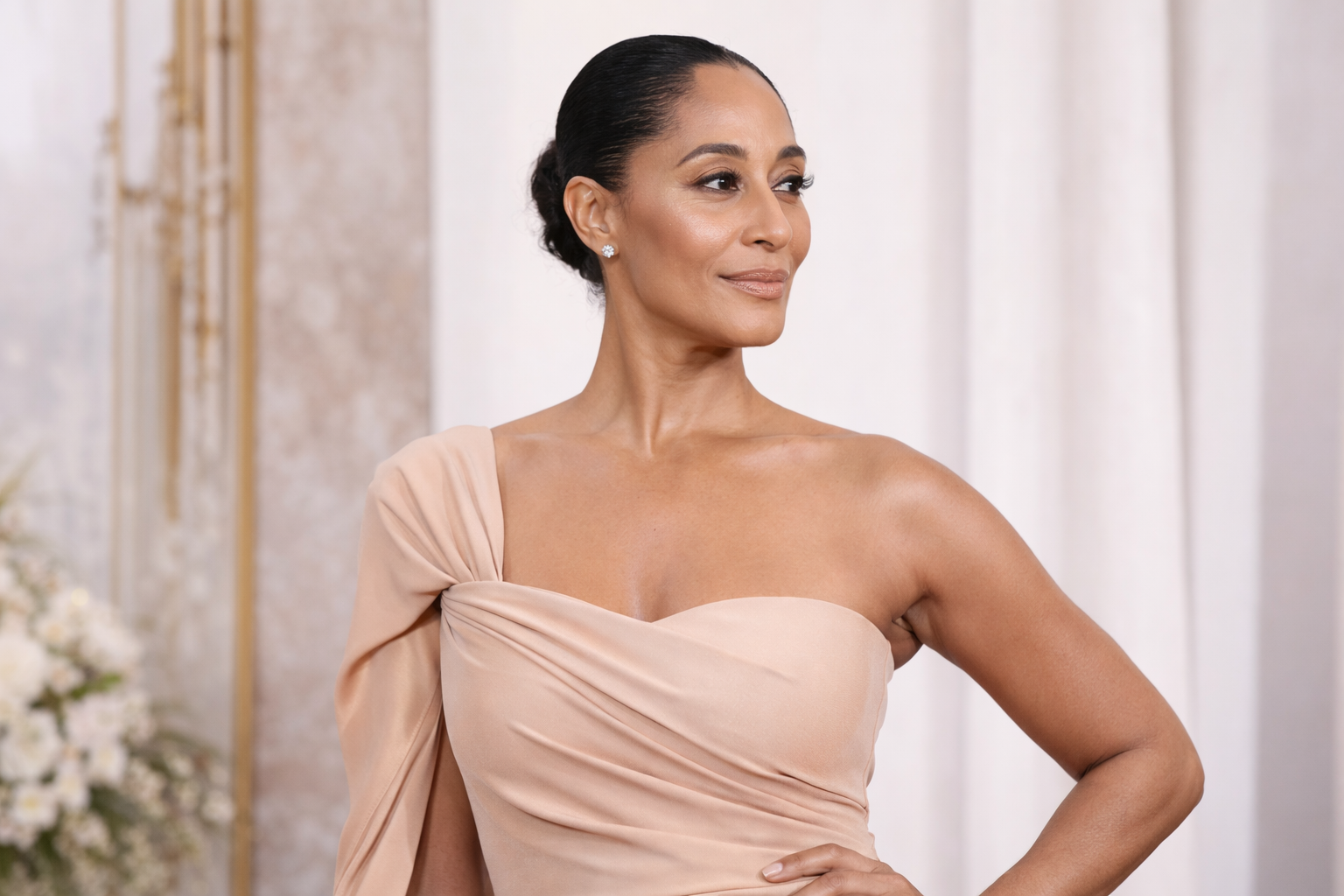 Tracee Ellis Ross wearing an elegant nude one-shoulder dress showcasing neutral fashion style