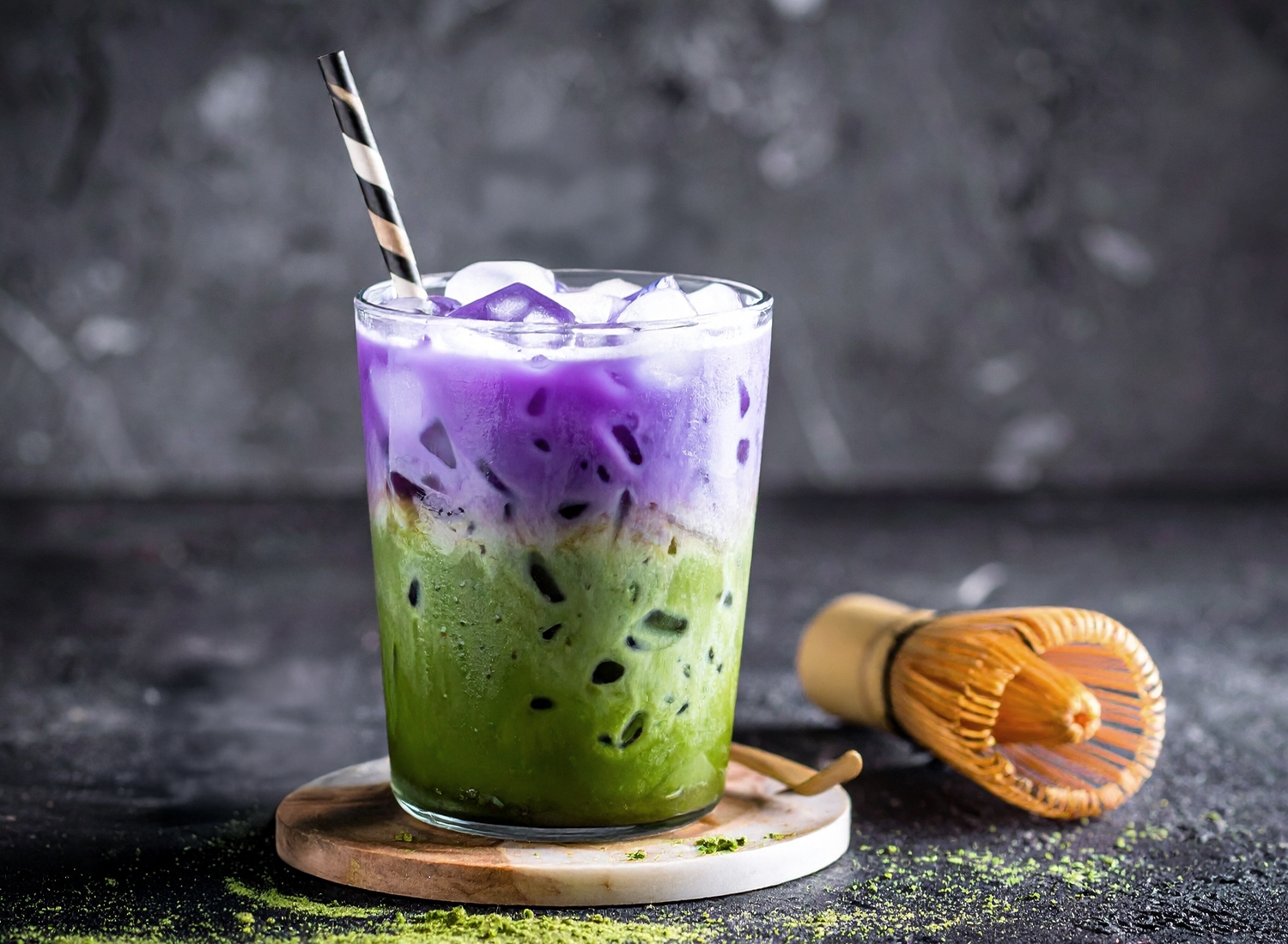 Ube and matcha layered latte with vibrant purple and green colors in a modern aesthetic setting