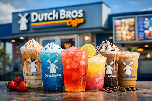 Colorful Dutch Bros drinks including iced coffee, blue energy drink, strawberry lemonade, and blended coffee served in front of a Dutch Bros coffee shop.